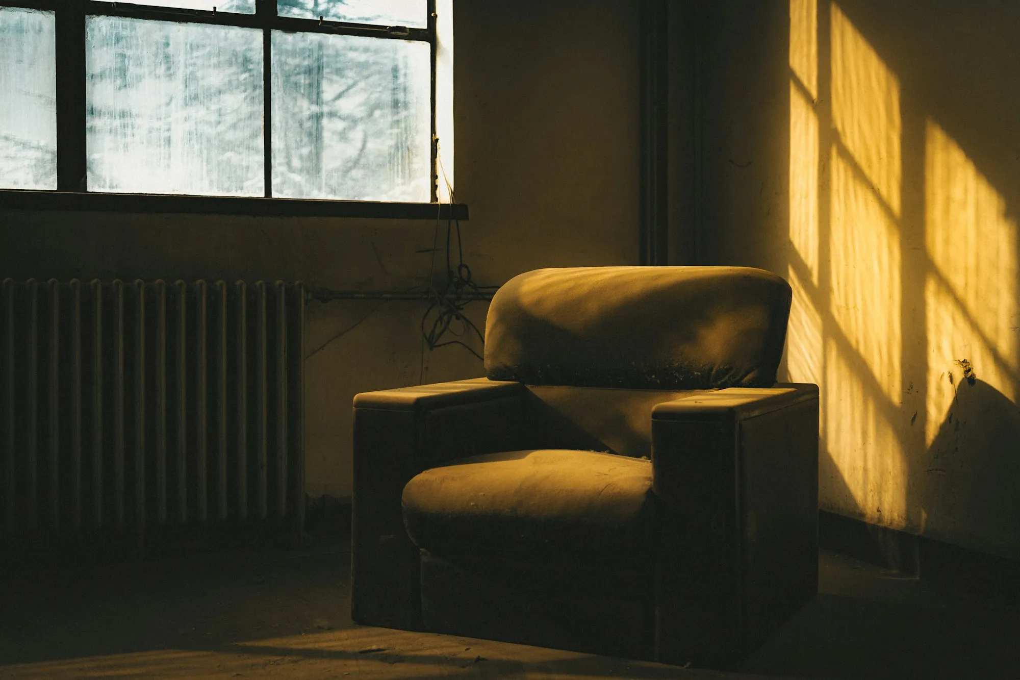 An armchair bathed in warm sunlight beside a window