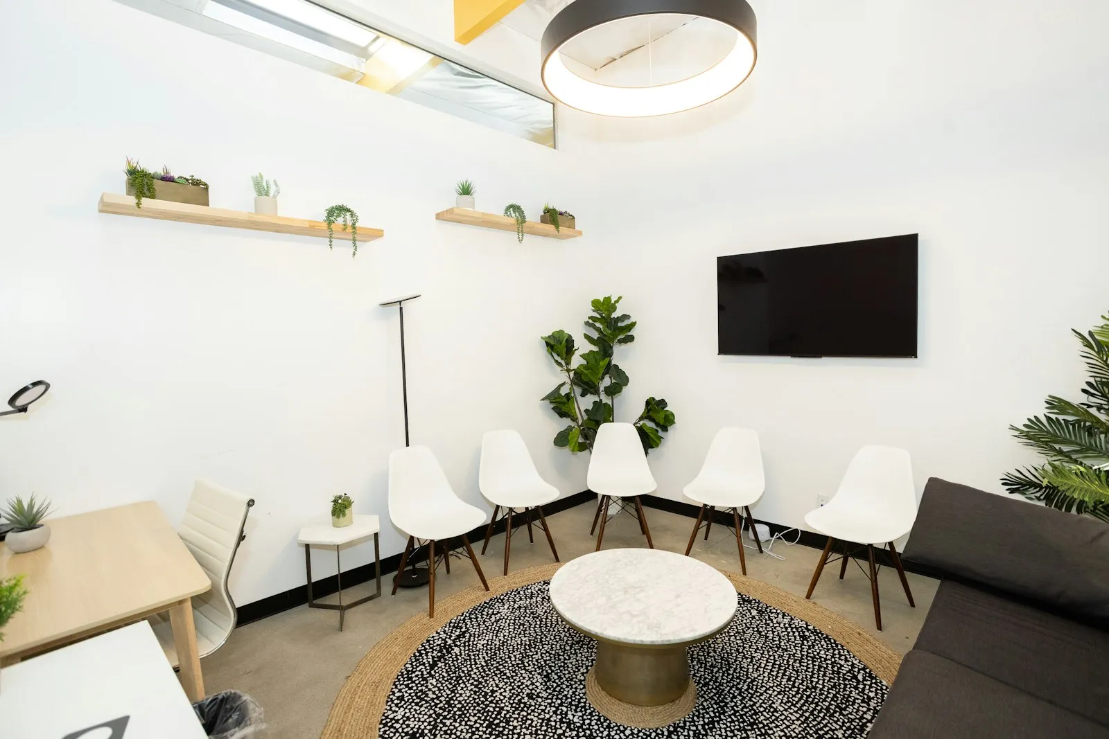 Two comfortable chairs in a bright, plant-filled room